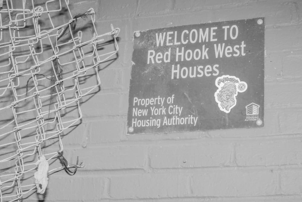 A sign reading "Welcome to Red Hook West Houses"